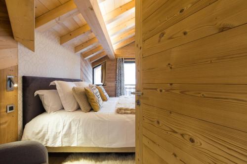 蒙特里永Chalet sur les monts Morzine的一间卧室配有带白色床单和枕头的床。