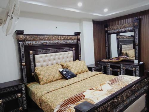 拉瓦尔品第HS Global Apartments的一间卧室配有一张床和一面大镜子