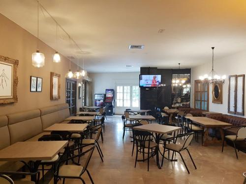 埃尔托沃索Hostal Restaurante Dulcinea de El Toboso的餐厅设有桌椅和平面电视。