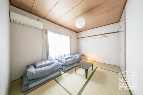 冈山Guest House MEETS Okayama 全室個室のホステル的客房设有两张床和窗户。