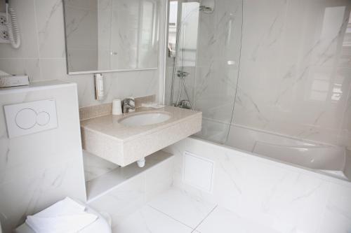 巴黎阿尔卡迪巴纳斯峰酒店的白色的浴室设有水槽和淋浴。