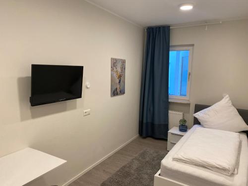 格尔梅斯海姆Hotel Quartier 8的客房设有一张床和壁挂式平面电视。