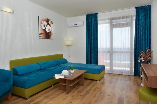 圣弗拉斯Paradise Beach Residence - Ultra All Inclusive的客厅配有蓝色的沙发和桌子