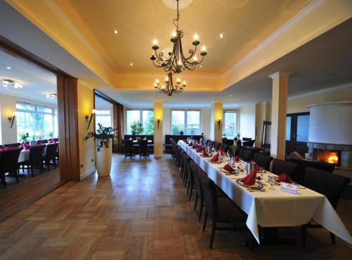 索托夫科尔德阿肯特酒店&玫瑰园餐厅的一间带桌椅和吊灯的用餐室