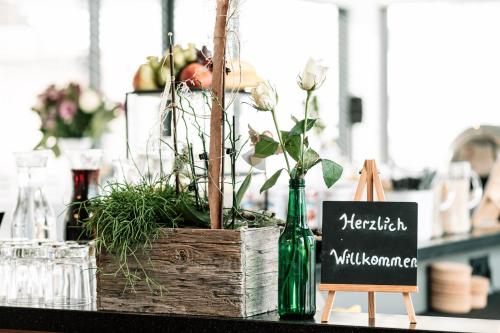 格里斯基兴Motel Grieskirchen superior的一张桌子,上面有木箱,上面有植物和标志