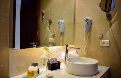 里韦拉里维拉赌场及度假村的一间带水槽的浴室和墙上的两部电话