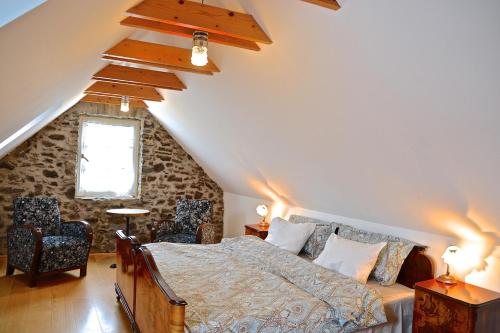 考波尔奇Kapolcs Cottage的阁楼上的卧室配有一张大床