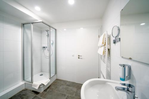 杜塞尔多夫Haus am Zoo Apartments verschiedene Adressen的带淋浴和盥洗盆的白色浴室