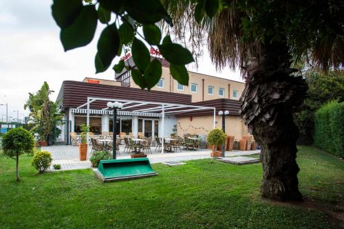 阿尔法法尔宜必思瓦伦西亚阿法法酒店的一座建筑,在树荫庭院里设有游泳池