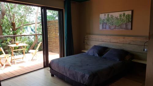 Sainte-SuzanneLe lodge origin的一间卧室设有一张床和一个滑动玻璃门