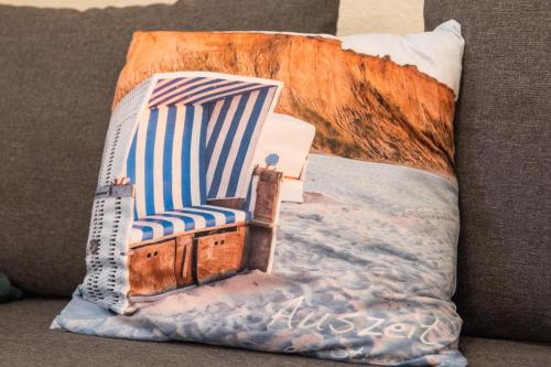 洛默Ferienwohnung Smillenzweg mit Garten的沙发上的枕头和沙滩椅
