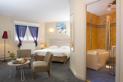 索姆河畔的圣瓦列里杜伯特德斯贝恩酒店的酒店客房配有一张床和浴缸。