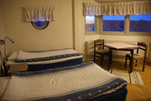 韦灵厄韦林格胡斯酒店的带3张床的客房,配有桌椅