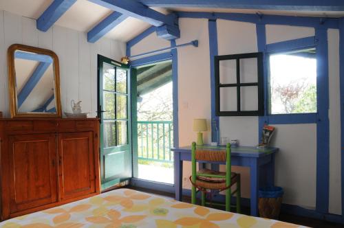 康博莱班Domaine Xixtaberri的客房设有桌子、书桌和窗户。