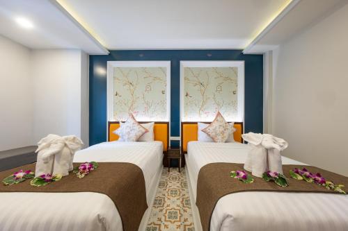 功孟海滩Sino Siam Hotel的带2扇窗户的客房内的2张床