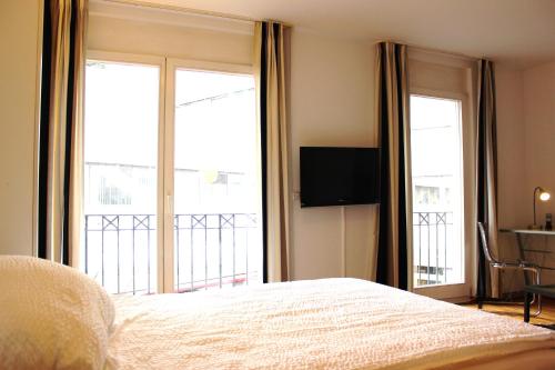 科隆a-partment Cologne Riverside的一间卧室设有一张床和两个大窗户