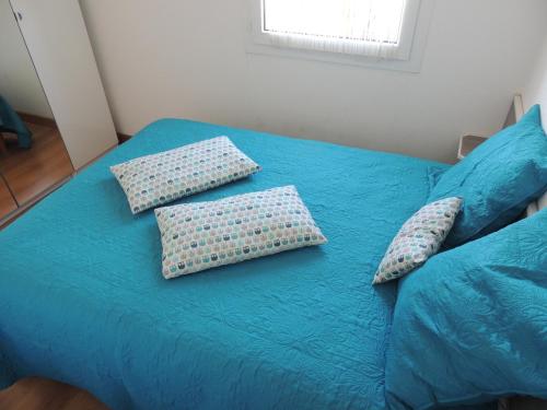 塞特港Cathymini à Sete的一张蓝色的床,上面有枕头