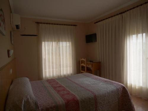 托雷利亚诺Hostal Durá的一间卧室设有一张床和两个窗户。