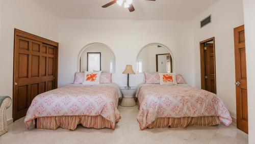 卡波圣卢卡斯Condominios Ballena的一间卧室配有两张床和镜子