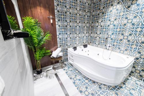 阿拉德צימר בוטיק אדלה Zimmer boutique adela的带浴缸和蓝色及白色瓷砖的浴室