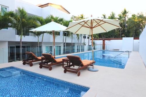 锡瓦塔塔内霍LYDMAR BOUTIQUE HOTEL的游泳池旁设有椅子和遮阳伞