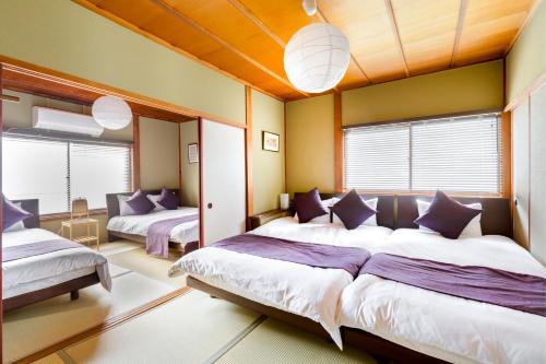 大阪Chikyuutabikazoku USJ Ⅱ的一间卧室设有两张床和两个窗户。