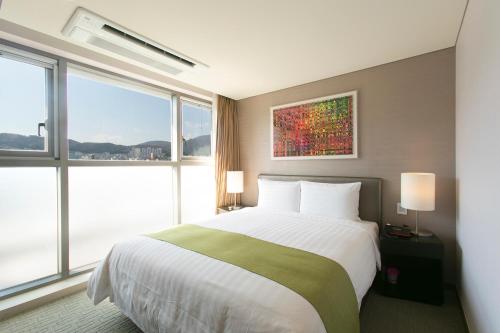 釜山阿文特里釜山酒店的一间卧室设有一张大床和大窗户