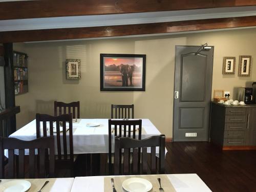 圣卢西亚Turaco Guest House的用餐室配有桌椅和墙上的照片
