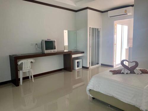 高兰Tan Residence的一间卧室配有一张床和一张书桌及电视