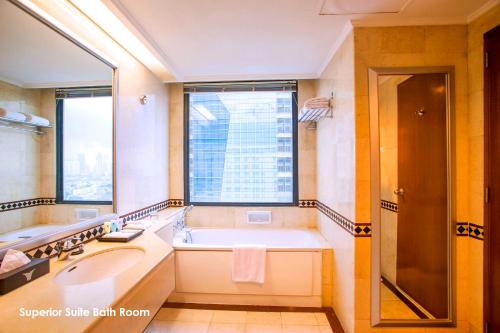 雅加达梅纳拉半岛酒店的带浴缸、水槽和窗户的浴室