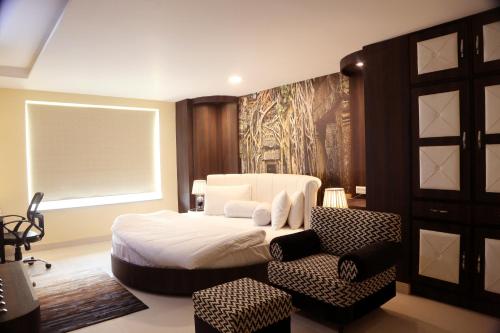 MogaKingdom Hotel的卧室配有白色的床和椅子