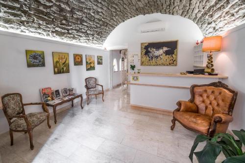 博萨Bosa Queen House的客厅配有椅子和墙上的绘画作品