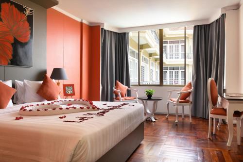 暹粒暹粒回忆酒店的一间卧室配有一张带橙色墙壁的大床