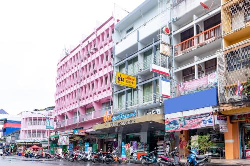 合艾Oun Residence的一条繁忙的城市街道,有许多建筑和摩托车