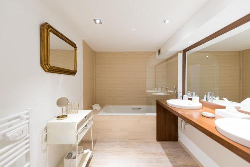 圣马丹德雷杰特酒店的浴室配有两个盥洗盆和浴缸。