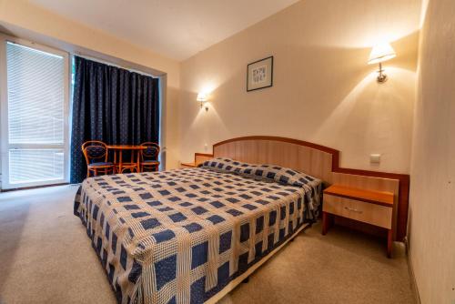 金沙丽利亚酒店的一间卧室配有一张床、一张桌子和一个窗户。