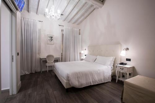 佛罗伦萨托纳伯尼景住宿加早餐旅馆的白色卧室配有一张床和一个吊灯