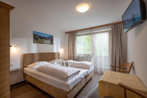 迈尔霍芬昆比奇霍夫旅馆的一间卧室设有一张大床和一个大窗户
