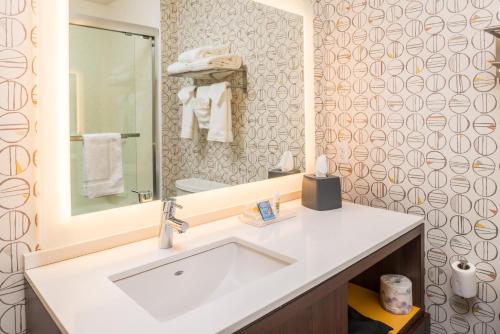 乔普林Holiday Inn Joplin, an IHG Hotel的浴室设有白色水槽和镜子