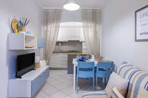 马尔恰纳Casa Gelso的厨房以及带桌子和蓝色椅子的客厅。