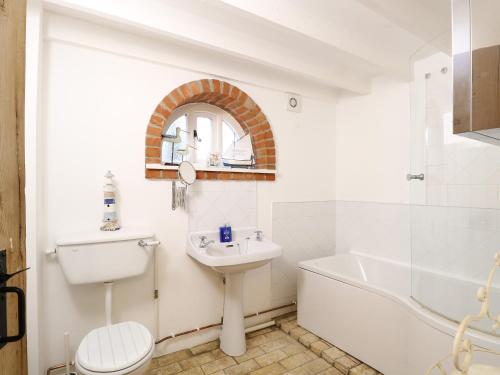 West BradenhamStable Cottage的一间带水槽、浴缸和卫生间的浴室