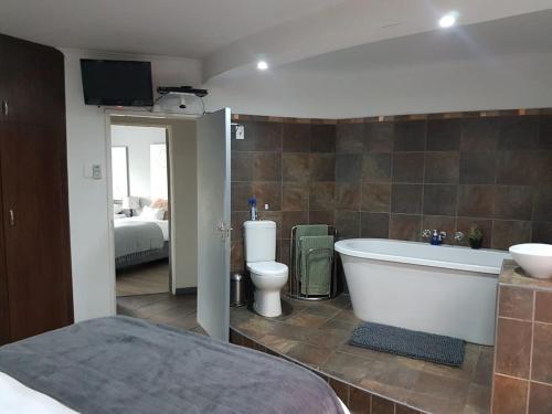 博福特西Karoo Heart的带浴缸和卫生间的浴室以及1张床。