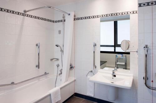 希灵登假日伦敦希斯罗艾丽尔酒店的白色的浴室设有水槽和淋浴。