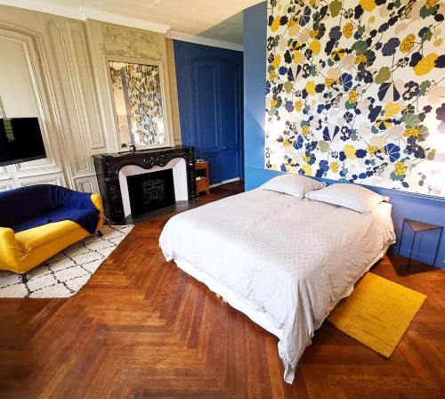 IngouvilleManoir des Carreaux Chambres d'hôtes的一间卧室配有一张床和一个壁炉