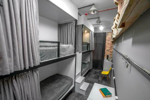 久姆里LOFT Hostel的小房间设有双层床和黄色椅子