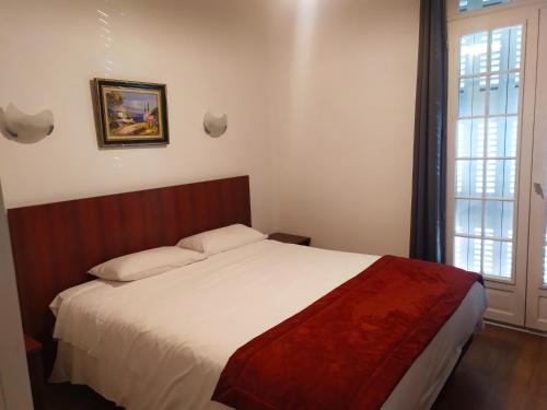 波城珀思提隆酒店的一间卧室设有一张床和一个大窗户