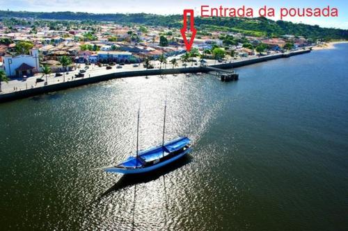 塞古罗港Pousadinha- Melhor Localização的城市旁边的水中一艘蓝色的船