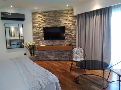 科隆Noha Casa de Campo的一间客厅,配有床铺和砖墙上的电视