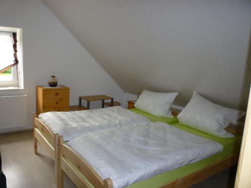MönchsdeggingenGasthaus - Pension Am Buchberg的一间卧室配有带白色床单和枕头的床。