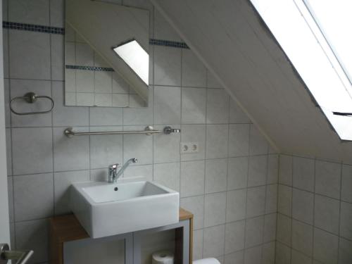 MönchsdeggingenGasthaus - Pension Am Buchberg的白色的浴室设有水槽和天窗。